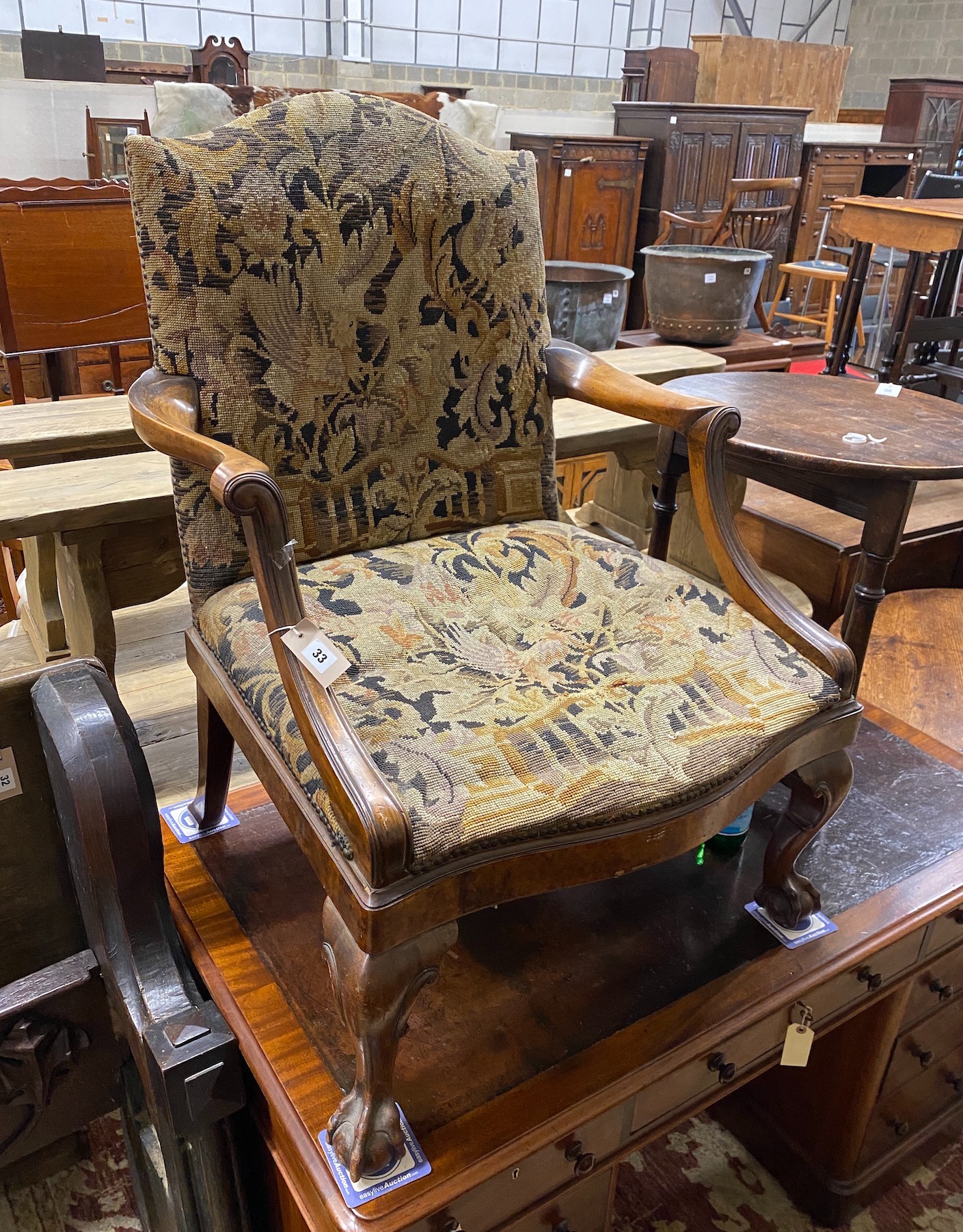 A George III style walnut Gainsborough type armchair, with polychrome tapestry upholstery, width 74cm, depth 60cm, height 100cm